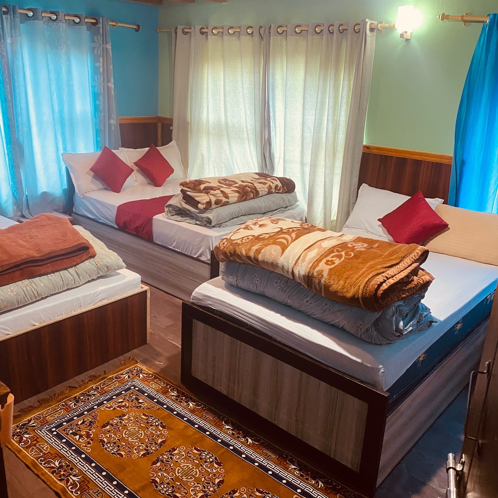 Family room with three beds, warm blankets and a Tibetan rug